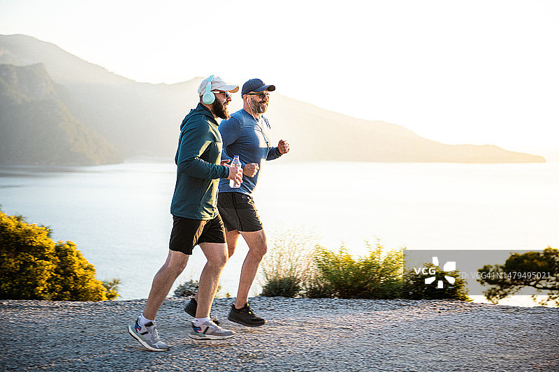 两个男人在日落时分在山中慢跑图片素材