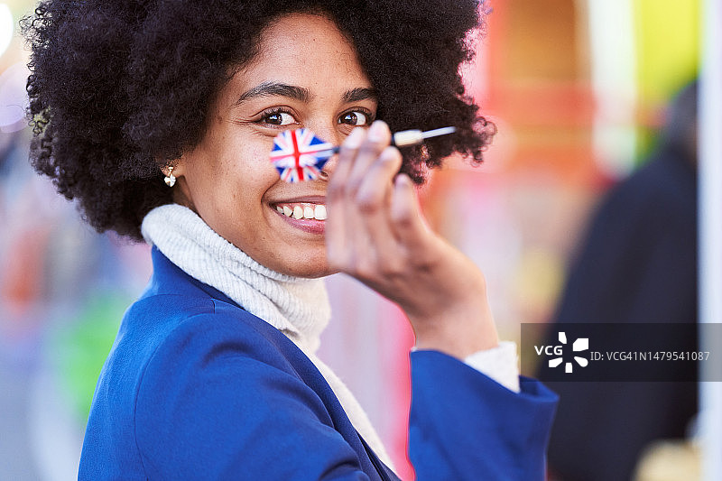 快乐的非洲裔妇女投掷带有英国国旗的飞镖图片素材