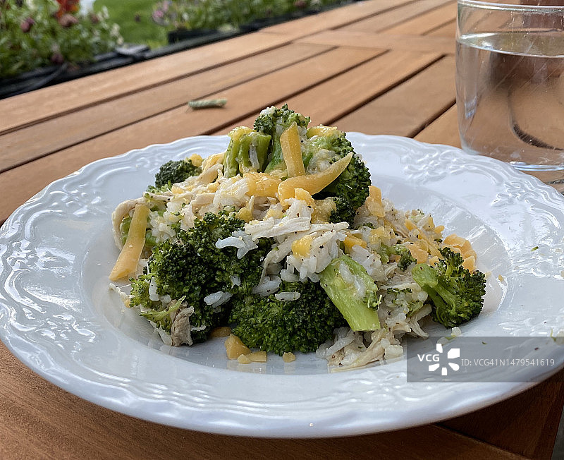 户外晚餐：鸡肉、西兰花、米饭和切达干酪图片素材