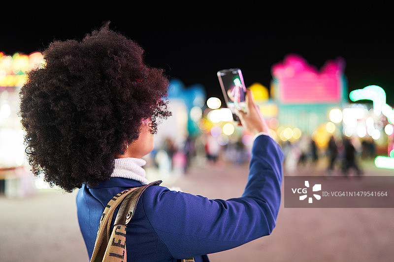非洲裔女人在集市上用手机拍照图片素材
