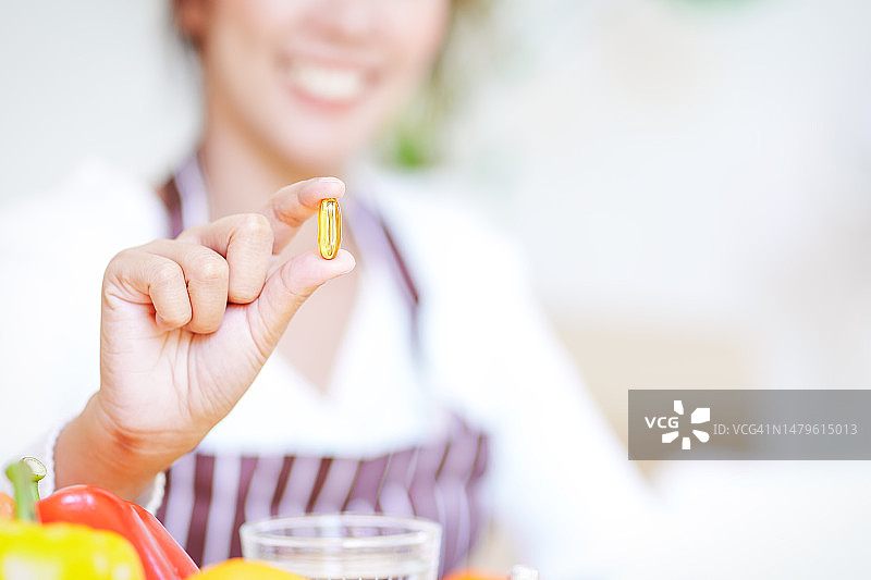 女人手持鱼油补充剂图片素材