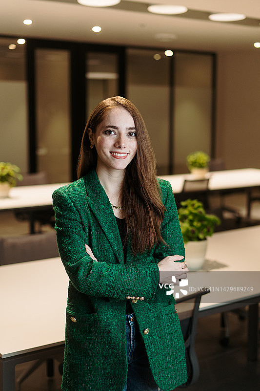 交叉双臂看着镜头的年轻女商人图片素材