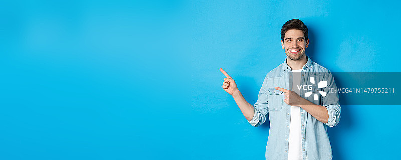 穿着休闲装的英俊白人男子指向左边图片素材