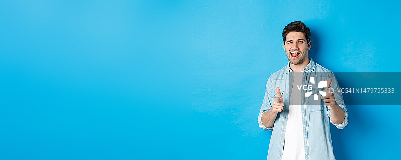 自信的成年男人眨眼并指向你图片素材