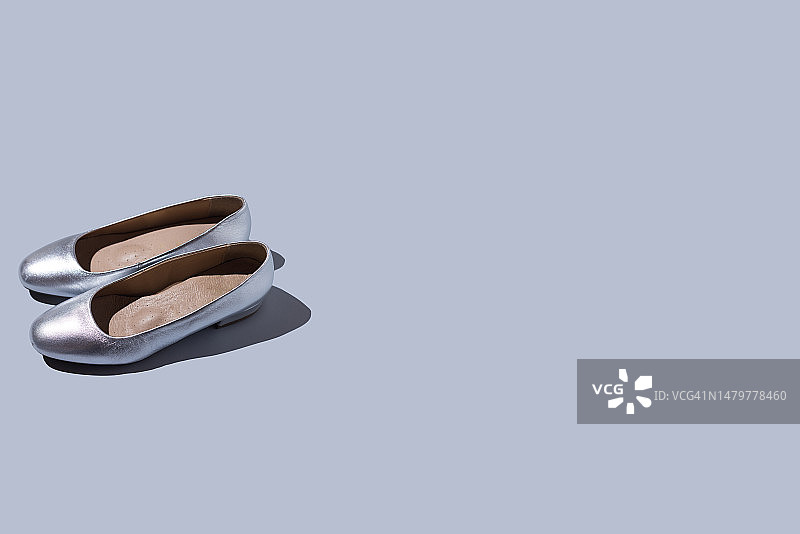 灰蓝色背景上的一双银色低跟女士鞋图片素材