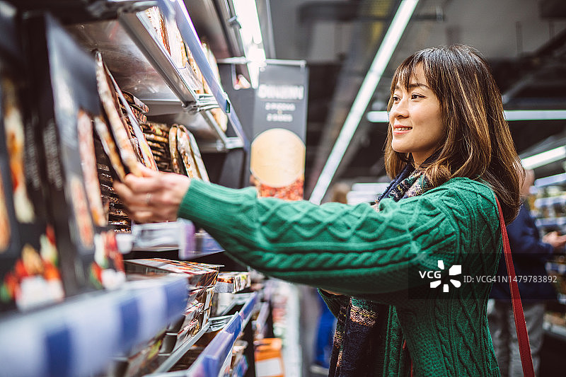 年轻漂亮女人在超市购买食品图片素材