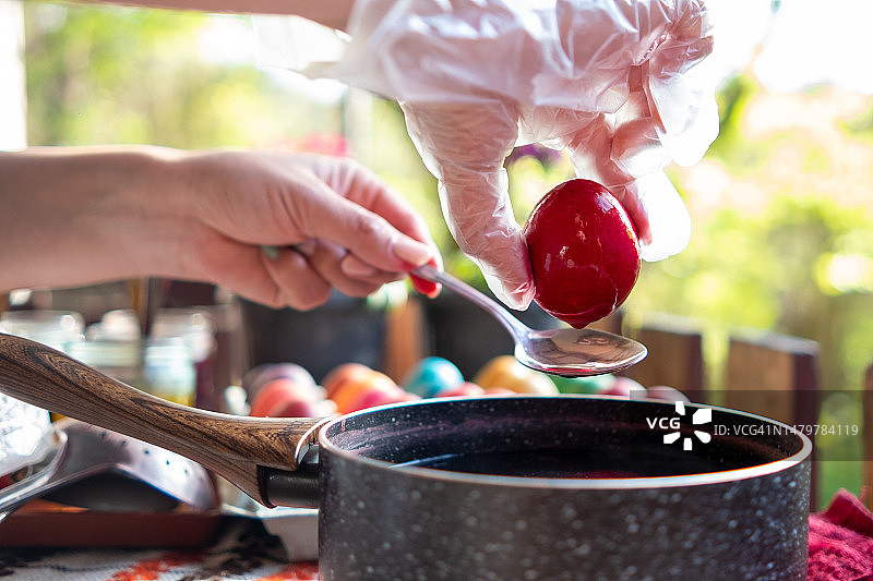 在森林小屋里为复活节彩蛋上色的年轻女子图片素材
