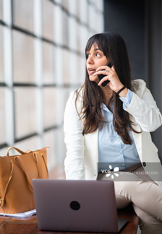 在办公室大厅里打电话的女商人图片素材