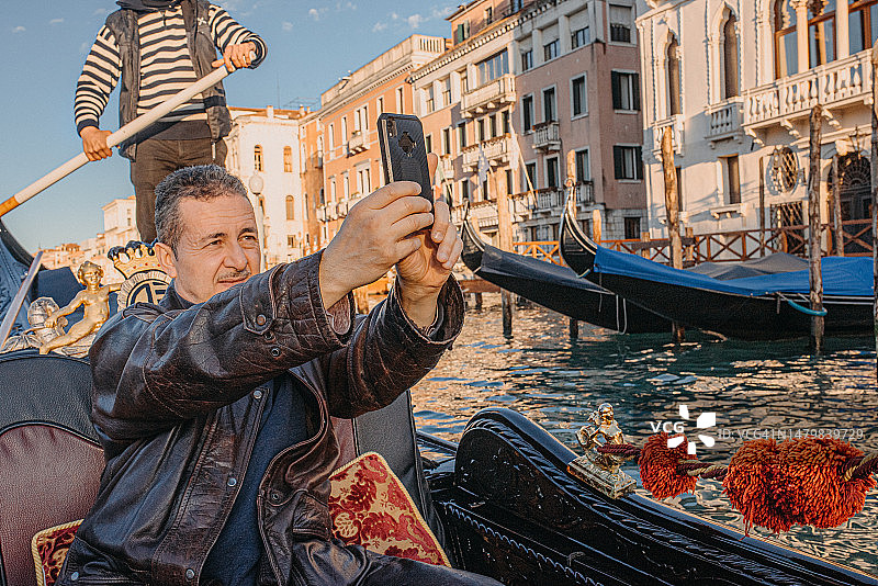 男子在缆车上用手机拍照图片素材