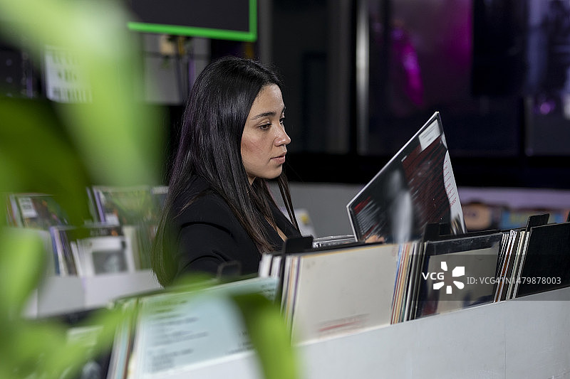 手里拿着黑胶唱片挑选的女孩图片素材