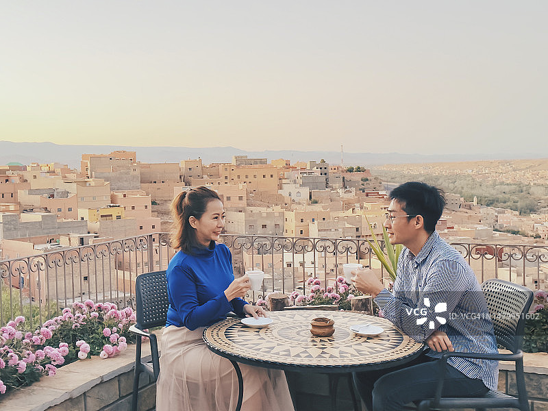亚洲华人情侣在摩洛哥布马尔内达德斯享用咖啡图片素材