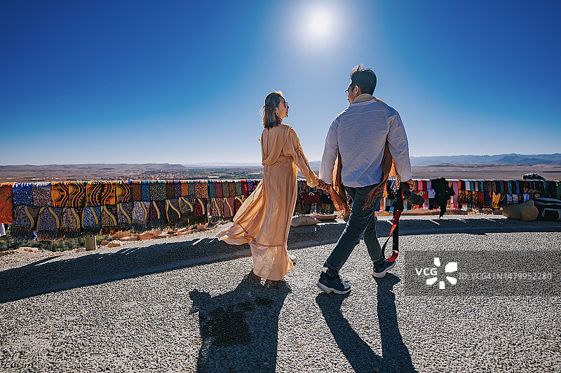 中国游客情侣在摩洛哥廷吉尔高处山坡欣赏风景图片素材