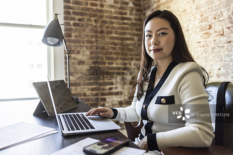 在现代办公室办公桌前工作的女商人图片素材