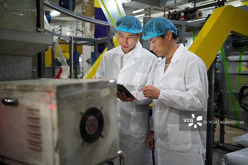 生产经理在车间使用平板电脑查看生产状态图片素材