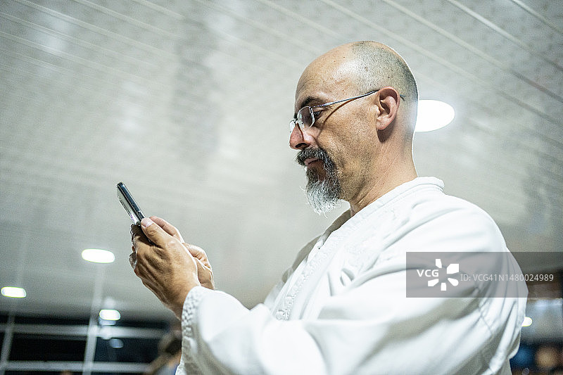 在空手道馆使用手机的中年男人图片素材
