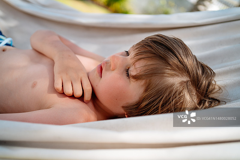 热带度假村：小男孩吊床休闲图片素材