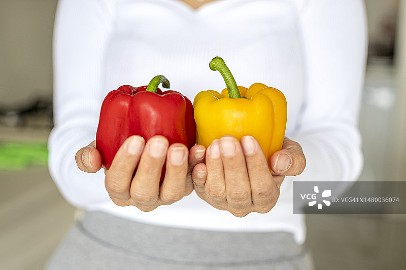 人手中的红色和黄色辣椒图片素材