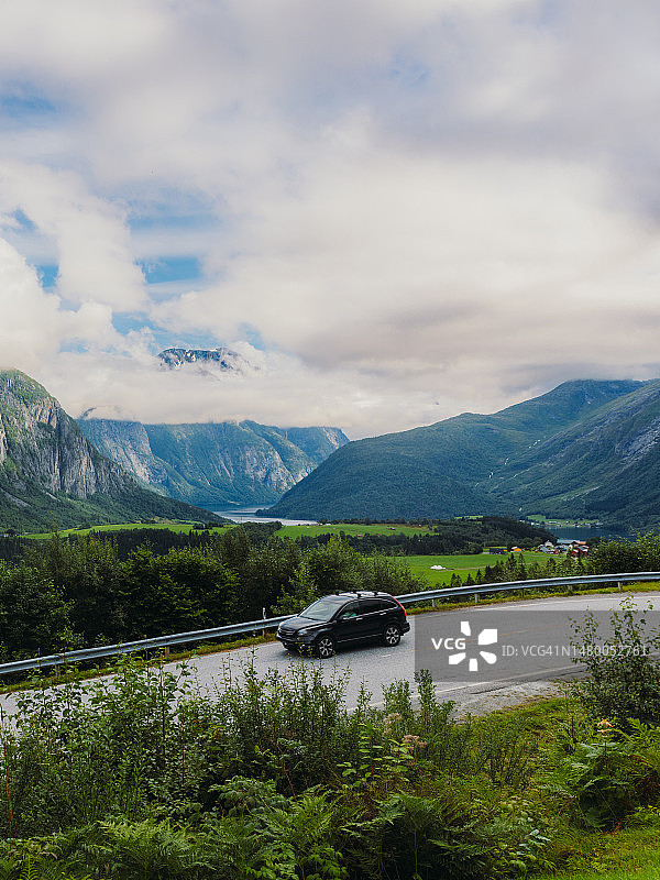 在挪威，汽车行驶在风景优美的道路上，欣赏夏季山景图片素材