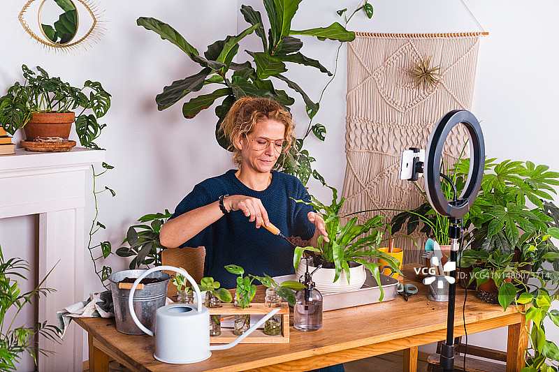 在家录制植物护理视频博客的女人图片素材