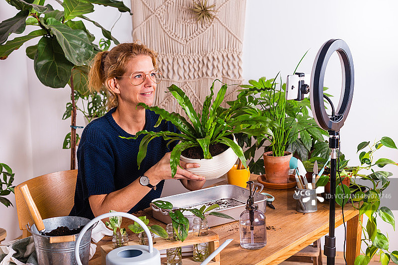 在家录制植物护理视频博客的女人图片素材