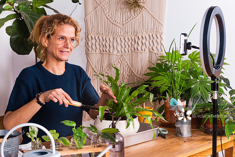 在家录制植物护理视频博客的女人图片素材