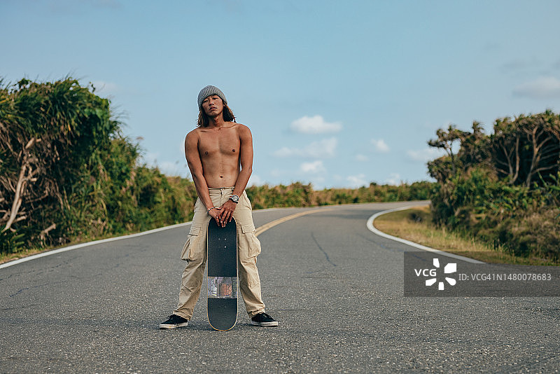 热爱滑板的年轻亚洲男人户外肖像照图片素材