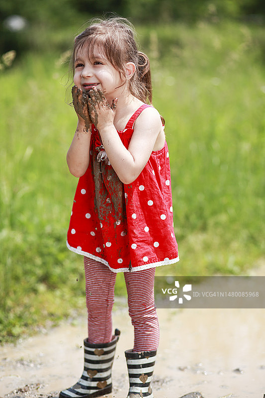 在泥地里玩耍的小女孩图片素材