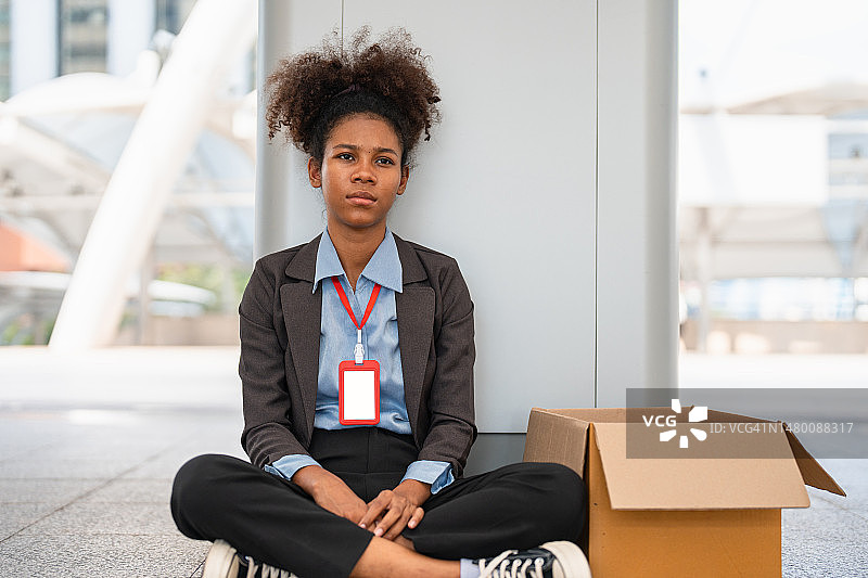 女商人带着装有个人物品的盒子离开办公室。图片素材