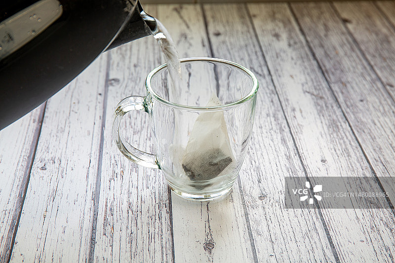沸水倒入装有茶包的玻璃茶杯中图片素材