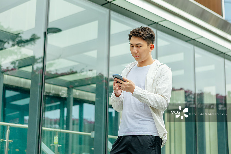 自信年轻男性商人在户外办公楼前图片素材