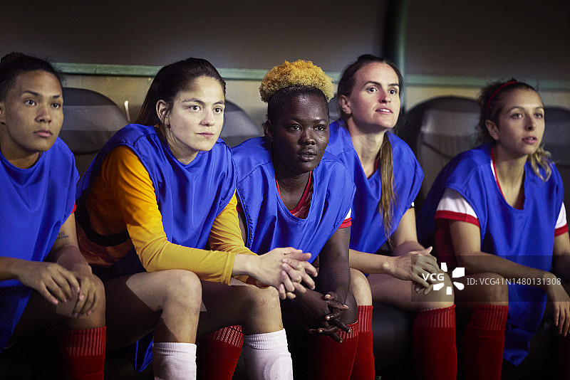 多文化背景的足球队员们观看队友比赛图片素材