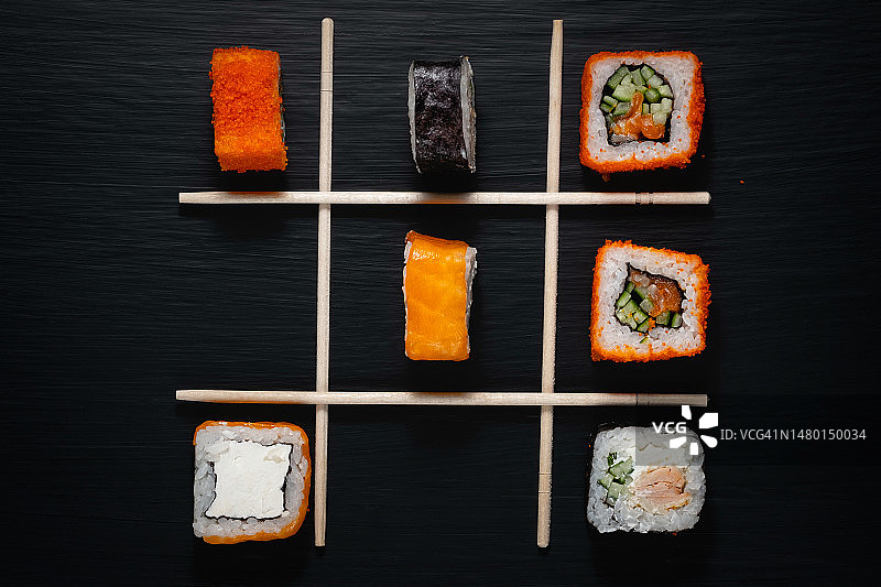 黑色木桌上的各种寿司和寿司棒，俄罗斯斯塔夫罗波尔图片素材