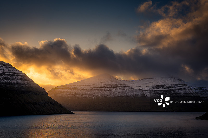 丹麦法罗群岛：日落时分的雪山湖泊图片素材