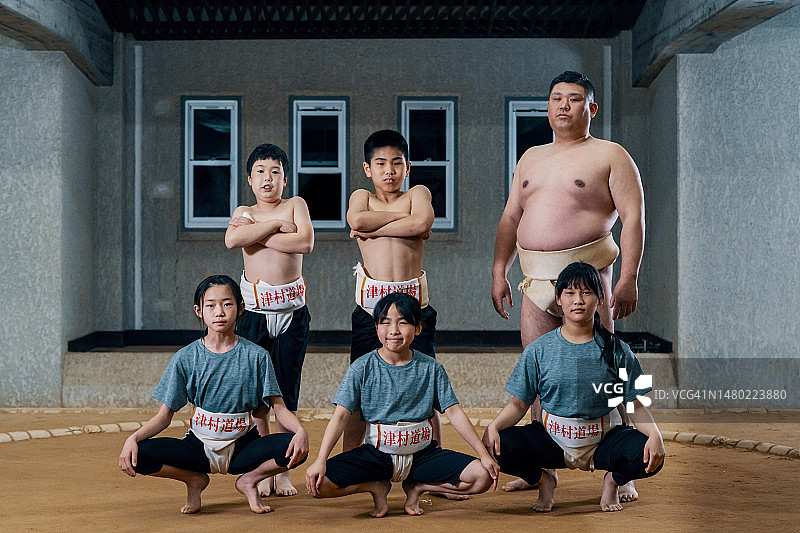 相扑教练和他的小学生在土俵上的肖像图片素材