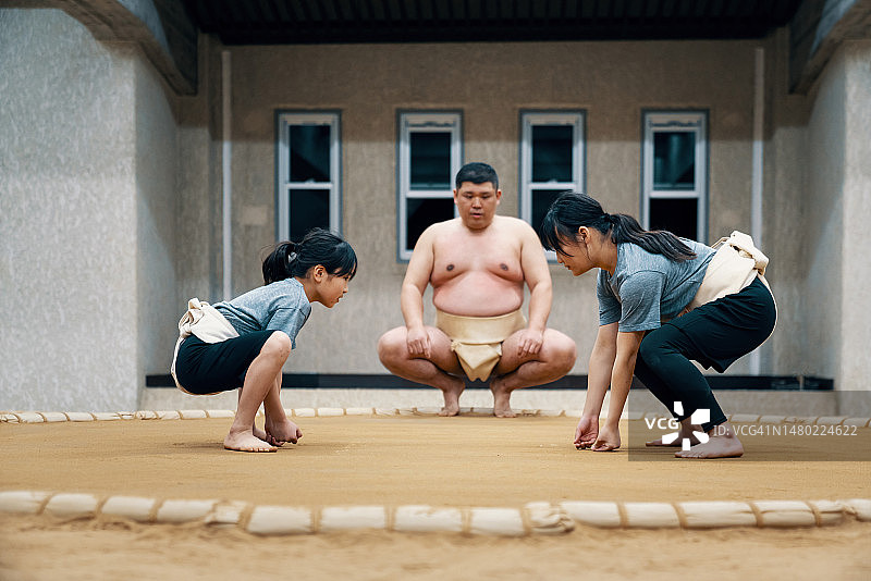 相扑教练指导两名小学生练习图片素材