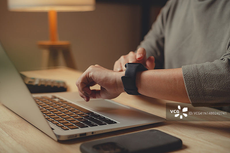 女性在家居办公室佩戴智能手表特写图片素材