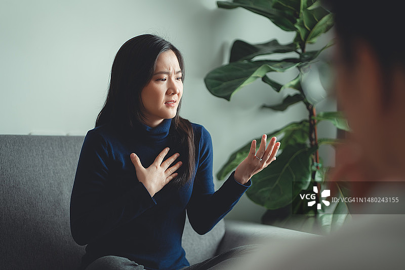 亚洲女性在咨询办公室的沙发上与心理医生讨论婚后问题图片素材