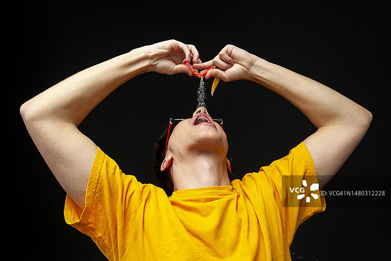 沉迷甜食的年轻人往嘴里倒糖图片素材