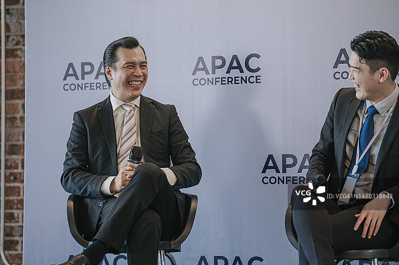 快乐的小组讨论：亚洲商人在商务会议研讨会上台演讲图片素材