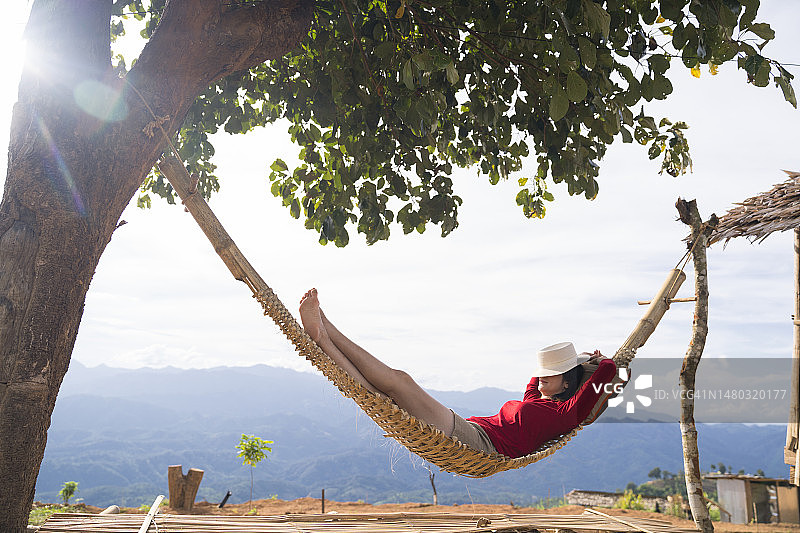 女人在美丽风景中的吊床上放松图片素材