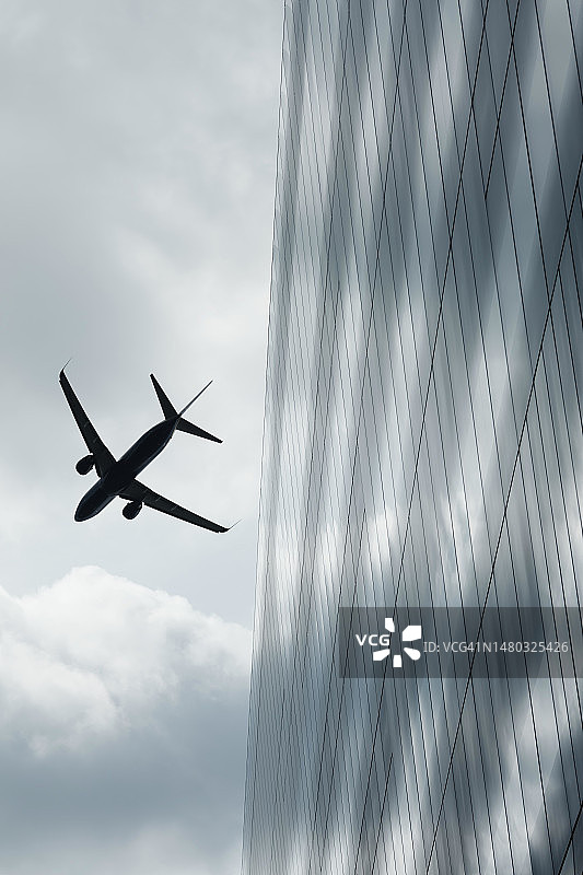 飞越办公楼的商用喷气式飞机图片素材