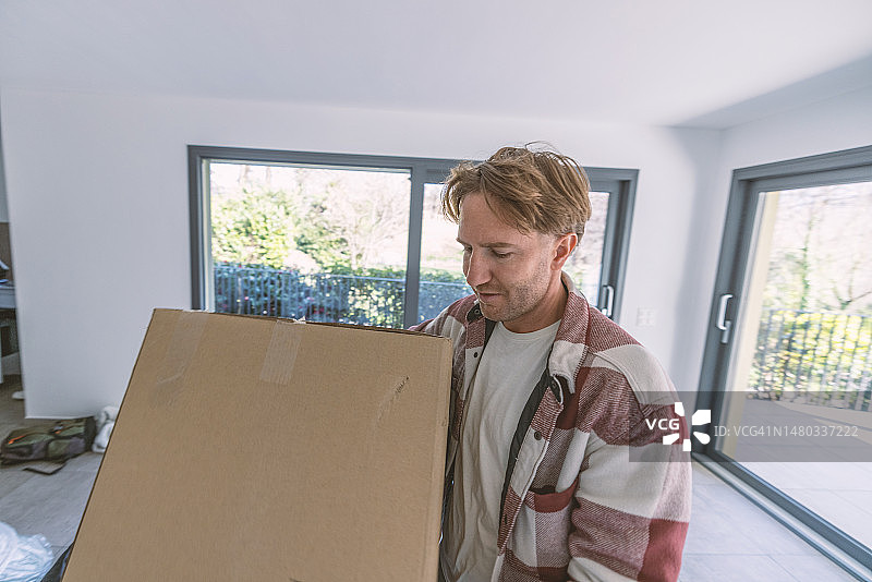搬家时搬运箱子的年轻男子肖像图片素材