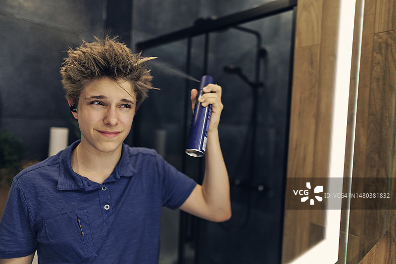 青少年男孩准备在现代化的黑暗浴室里外出图片素材