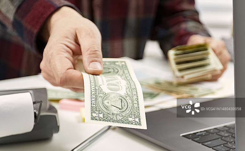 男人手持美元钞票点钱的特写图片素材
