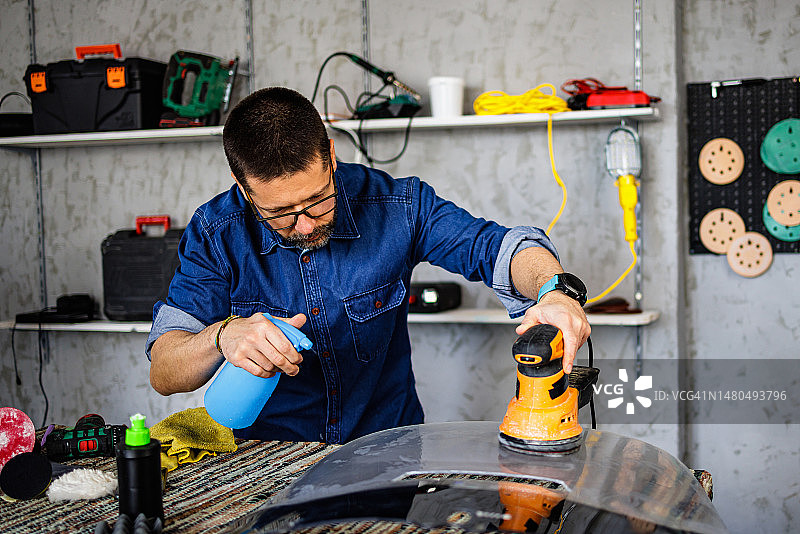 用砂光机进行精密工作的维修工人图片素材