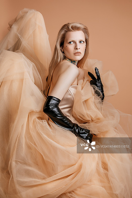 一位穿着奶油色连衣裙的漂亮金发女人图片素材