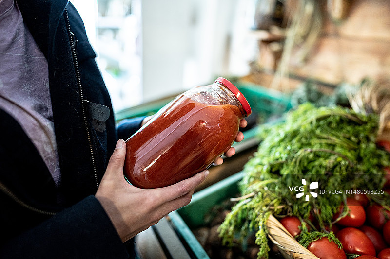 在市场上拿着番茄酱罐子的女人图片素材