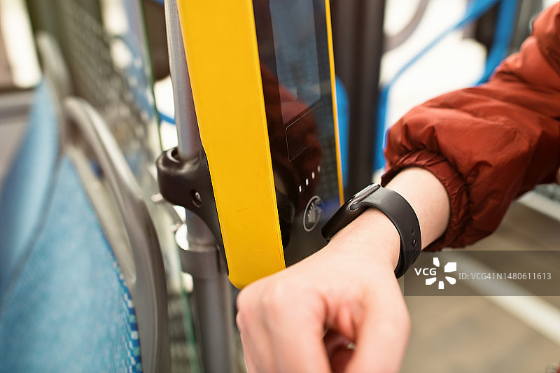 女人用智能手表支付公交车票图片素材