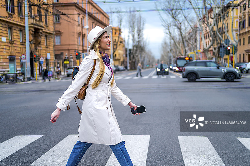 快乐的年轻女子过马路图片素材