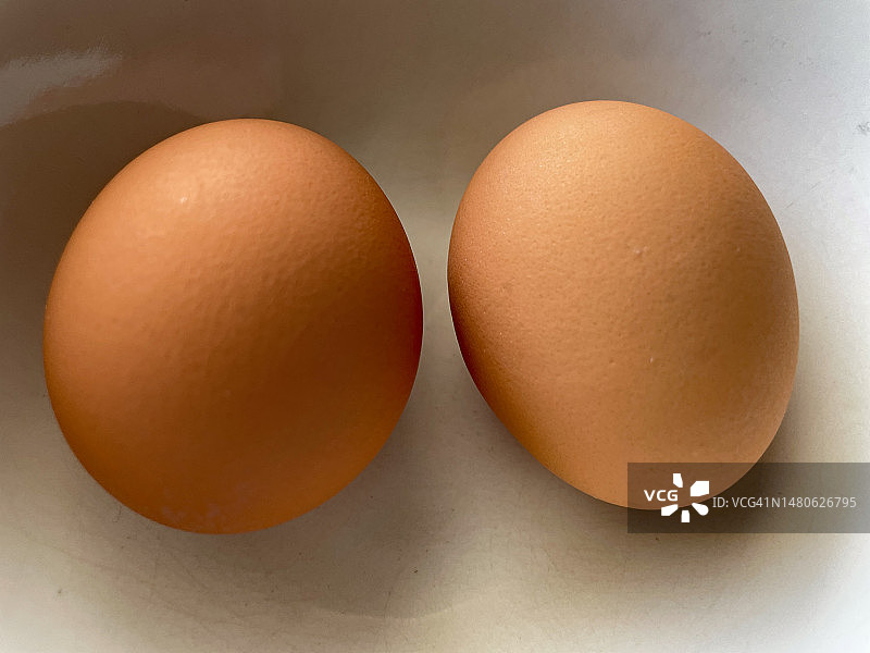 碗中放置的完整生鸡蛋或煮熟的鸡蛋图片素材